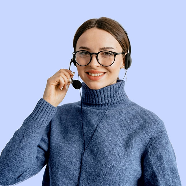 Ciemnowłosa kobieta w niebieskim golfie, w okularach i z zestawem słuchawkowym.