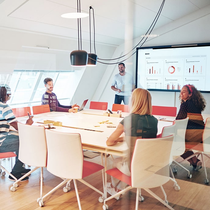 Spotkanie zespołu, na którym dyskutuje się o danych ankietowych wyświetlonych w panelu.