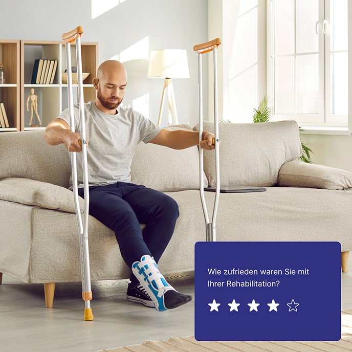 Ein kahlköpfiger, bärtiger Mann mit einem eingegipsten Bein sitzt auf einem Sofa und hält Krücken in den Händen.