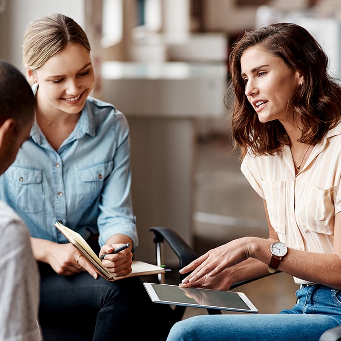 Kierowniczka działu kadr prowadzi rozmowę z dwoma kolegami, mężczyzną i kobietą, którzy robią notatki.