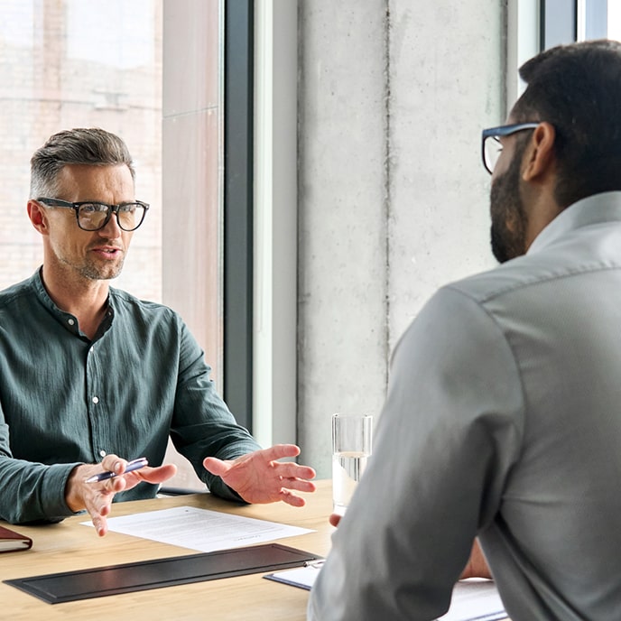 Dwoje pracowników dyskutujących w pracy